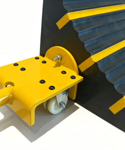 Wheel Chocks Attachment Brackets » Highway 1 Close-up of a yellow wheeled industrial trolley attached to a black corrugated track with yellow safety tape; a white wheel supports the assembly and a bolt passes through a yellow bracket.