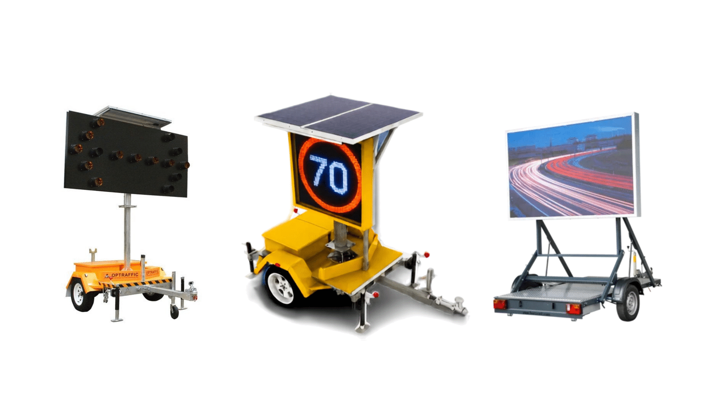 Three mobile traffic displays on trailers: a large LED sign, a solar-powered speed radar showing 70, and a highway billboard on a trailer side-by-side.