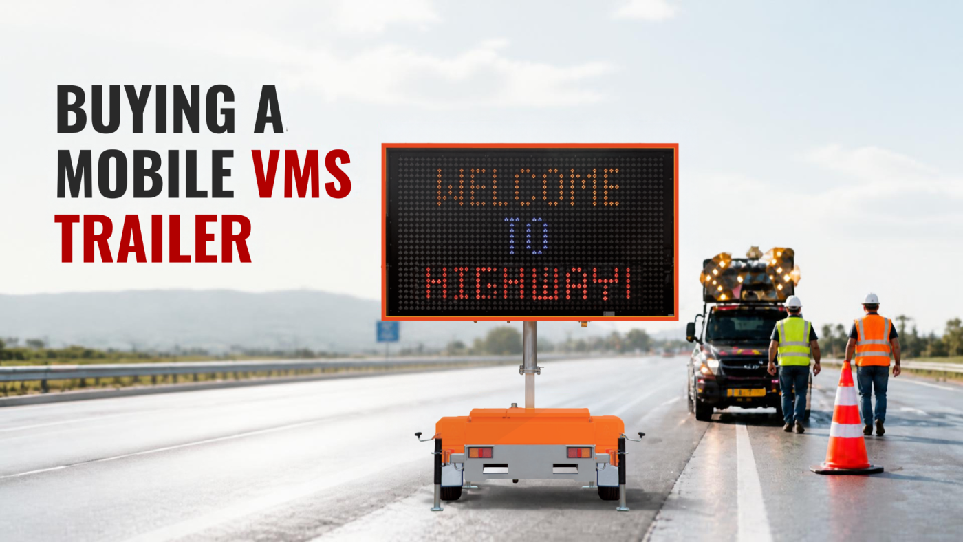 questions to ask when buying a mobile vms trailer » Highway 1 Large text banner reading 'Buying a Mobile VMS Trailer' beside an orange portable LED sign on a highway, with workers in hi-vis vests nearby.